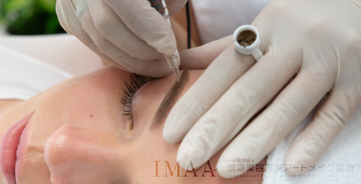 眉の医療アートメイクを受けている女性と施術者の手のアップ